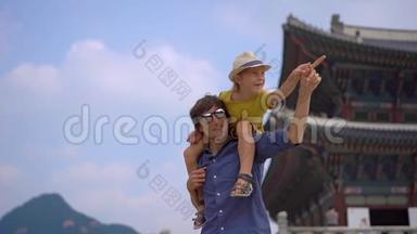 年轻人和他的小儿子参观了韩国首尔的古代宫殿。 前往韩国的概念.. 慢镜头